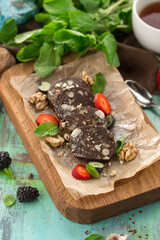 Delicious chocolate roll cake with nuts and cup of tea on the table