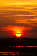photo of big sun at sunset or evening time over the lake.