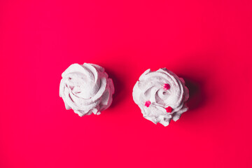 Fresh marshmallows on a pink background. Zephyr, meringue. The concept of home-cooked food, sweets. Minimalism, top view, flat lay, copyspace.