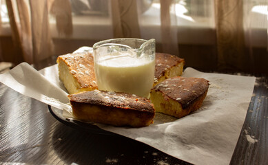 basque cheesecake on the table with sour cream and milk