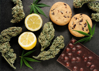Sweets with CBD oil. Marijuana buds on black background. Cannabis flowers and chocolate cookies...