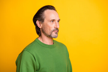 Profile photo of concentrated focused man look empty space wear green pullover isolated vibrant yellow color background