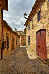 A narrow street between the old houses of Montecosaro, a medieval town in the Marche region of Italy.