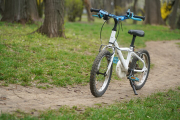 Fototapeta na wymiar A child's bicycle on a path in the woods. Photo during the day.