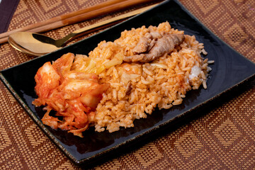 Kimchi fried rice in black plate, Korean food style close-up