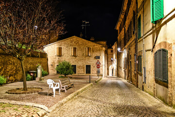A narrow street between the old houses of Montecosaro, a medieval town in the Marche region of Italy.