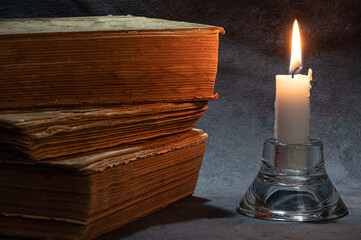 a stack of old books and a candle