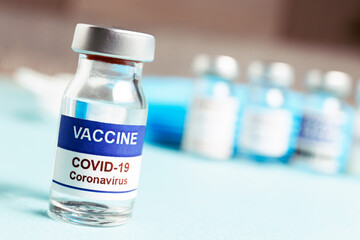 Macro shot of antiviral vaccine vial for immunization against covid-19 virus. Blurred out background with copy space for text. Close up, top view.