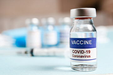 Macro shot of antiviral vaccine vial with syringe for immunization against covid-19 virus. Blurred...