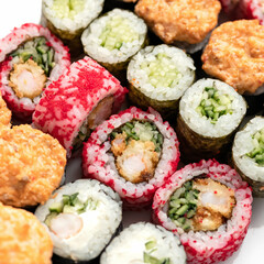 Sushi Set. Different types of raw and baked sushi rolls. Asian or Japanese food, Oriental cuisine. Close up shot. Top view. Soft focus.