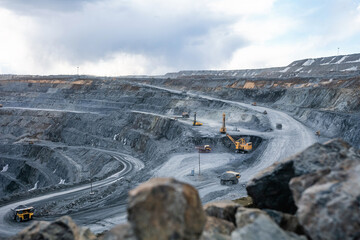 Work of heavy equipment in an open pit for gold ore mining