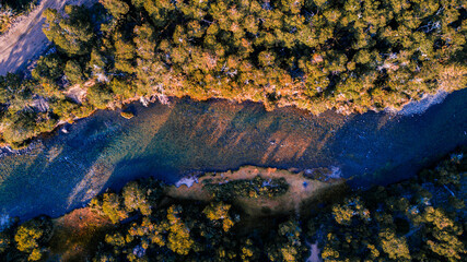 vista cenital de un rio del sur argentina, abriéndose camino entre las montañas y el bosque con sus aguas transparentes y cristalinas producto de deshielo de montañas