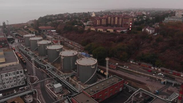 Large oil refinery on the bank of the mora with its own cargo port next to residential areas of the city. Aerial view