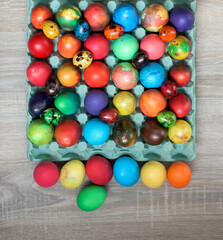 Multicolored painted hens and quail easter eggs in egg carton