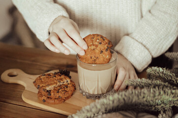 a woman dips cookies in milk
