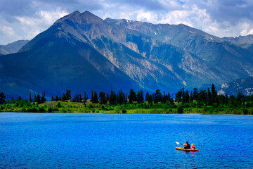 Man on Kayak on Lake Mountains Wilderness Paddling