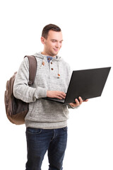 Young guy in casual clothing and backpack holding open laptop