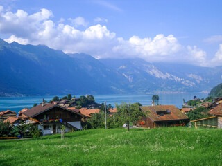 Obraz premium swiss village at a lake in canton bern with mountains and clouds on a sunny day