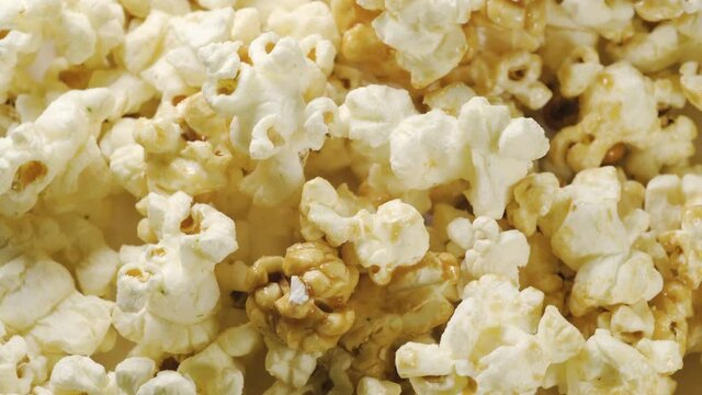 Popcorn closeup with rotating. Background with cinema popcorn celebrate. Snack food with corn, caramel and salt.