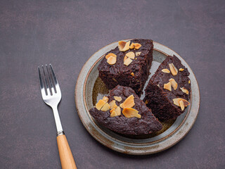 Pieces of fresh brownies on a plate with a vintage background. Side view. Delicious chocolate pie. Dessert and relaxation concept