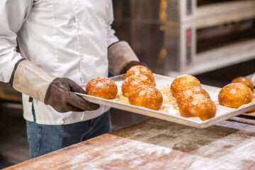 Mans hands holding tray of fresh rolls