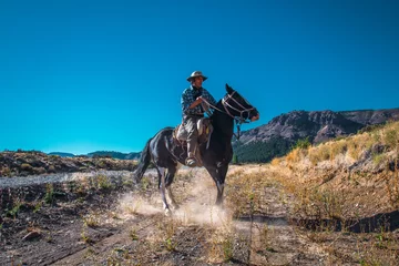 Crédence de cuisine en verre imprimé Buenos Aires Argentine cowboy (gaucho) walks his horse past camera, in Patagonia.