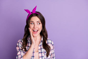 Photo portrait of astonished girl touching face with one hand looking at blank space isolated on vivid purple colored background