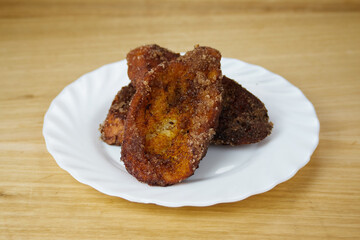 Traditional homemade and Delicious Spanish Torrijas in a white dish.