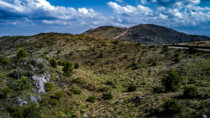 Las montañas mas altas, con las nubes pasando sobre ellas y el camino bordeando la base de la montaña hasta el horizonte. Cerro Champaqui. Merlo. Córdoba. Argentina