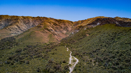 Las montañas mas altas, con las nubes pasando sobre ellas y el camino bordeando la base de la...