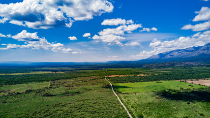 Las montañas mas altas, con las nubes pasando sobre ellas y el camino bordeando la base de la...