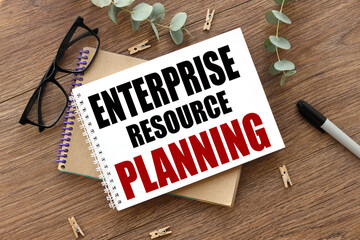 enterprise resource planning (ERP). text on white paper over torn paper background.