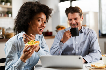 Loving couple drinking coffee and eating sandwich. Happy smiling wife enjoy in the morning with her husband