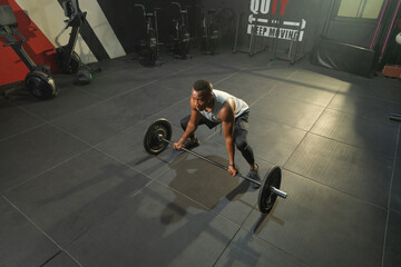 Black African American man lifting sport bar. Muscle strength training workout at gym fitness...