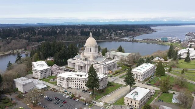 Cinematic aerial drone footage of the springtime cherry blossoms at the Washington State Capitol Building and Campus, Capitol Lake, Tivoli Fountain and surrounding park in Olympia, Washington