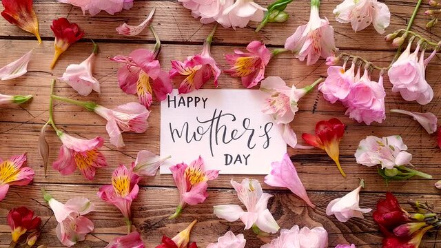 HAPPY MOTHERS DAY card on a wooden table top view 