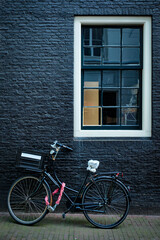 Fototapeta na wymiar Bicycle near wall of old house in Amsterdam street
