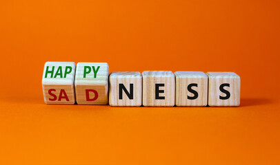 Happyness or sadness symbol. Turned cubes and changed the word 'sadness' to 'happyness'. Beautiful orange background. Business, psychological and happyness or sadness concept. Copy space.
