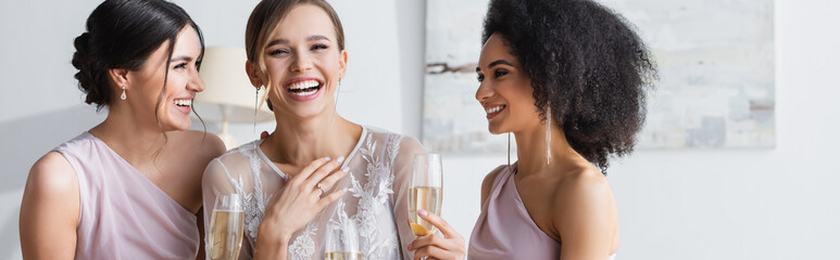 excited bride laughing near friends holding champagne glasses, banner.