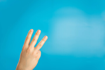 Hand of caucasian man showing fingers over isolated blue background counting number 3 showing three fingers. Hand sign on blue background. right hand a man show the third, number three sign