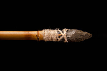 prehistoric javelin tied to a pole. Stone age. paleolithic. on black background