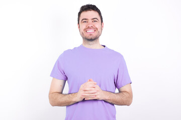 Business Concept - Portrait of young handsome caucasian man wearing purple t-shirt against white background holding hands with confident face.