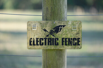 Sign of electric fence to keep cattle inside the fence