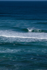 Fototapeta premium Big blue wave breaks in a dark blue ocean