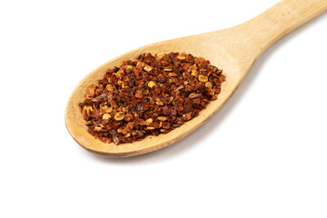 Closeup of dried calabrian chili pepper on a wooden spoon isolated over white background