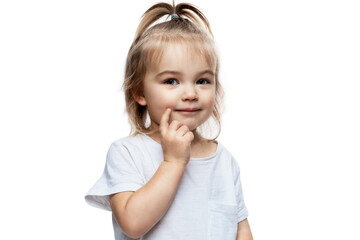 Smiling little girl 2 years old in a white T-shirt. The blond baby put her hands to her face....