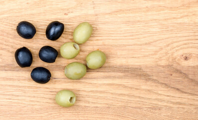 Black and green marinated olives isolated on a wooden background