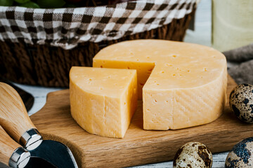 Cheese dish with organic cheeses, fruits, nuts on a wooden background. Delicious cheese snack