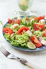 Salad with Green Olives, Tomatoes and Feta Cheese. Bright wooden background. Close up.	