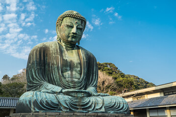 The Great Buddha or Daibutsu at Kotoku-in Buddhist Temple. A large bronze statue found in Kamakura, Japan. Photographed with a bright blue sky.